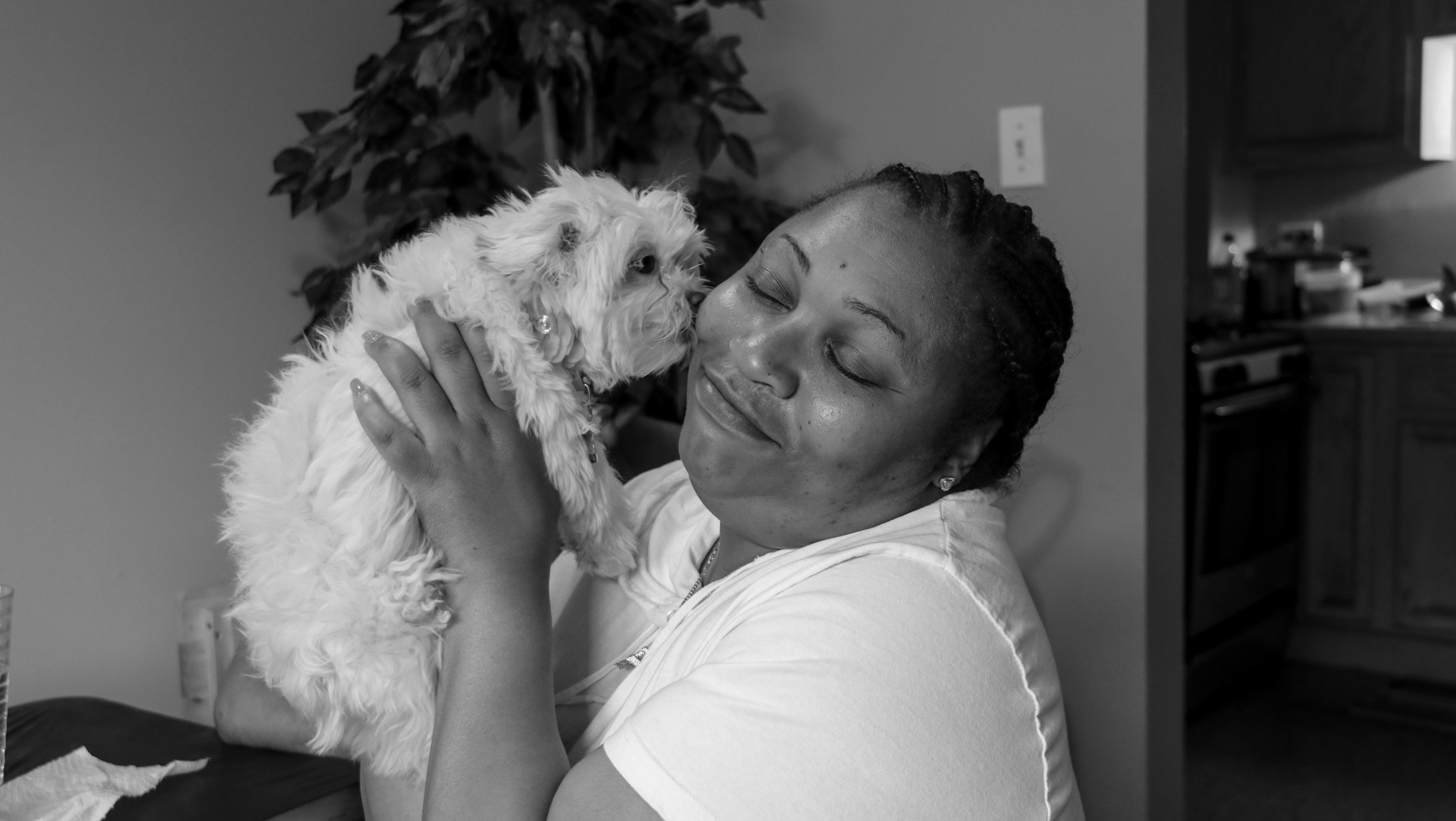 woman holds small dog to her cheek